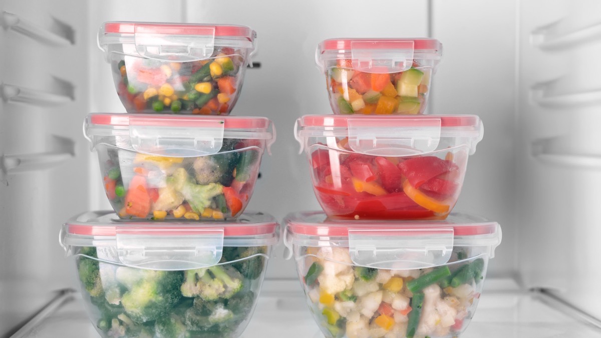 Stacked, labelled food containers on a fridge shelf